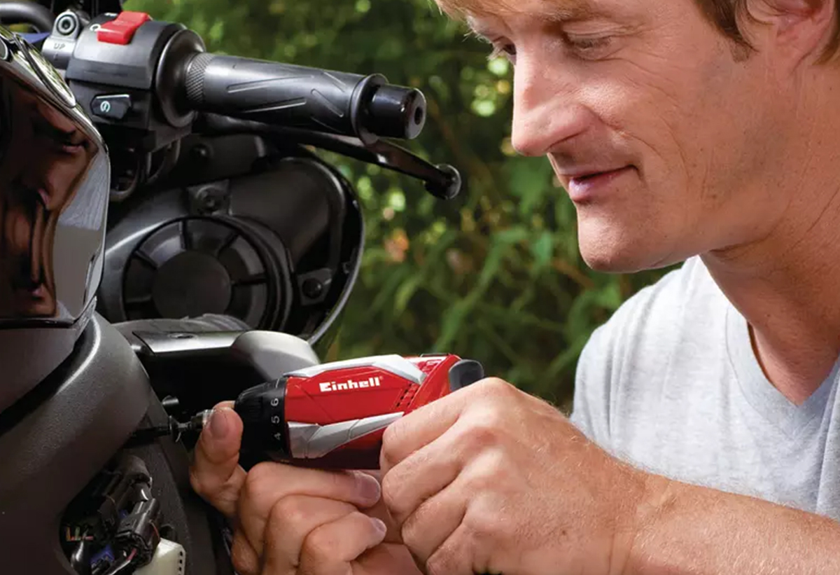 Ένας άντρας χρησιμοποιεί το κατσαβίδι σε μία μηχανή.